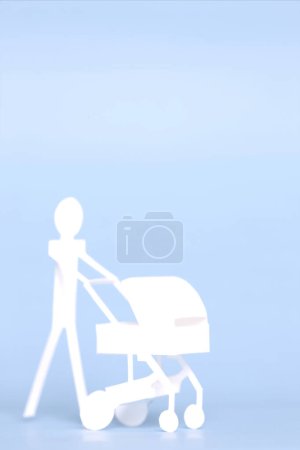 Foto de Lindo hombre de papel blanco con cochecito de bebé de papel - Imagen libre de derechos