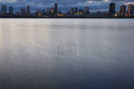 Photo for Beautiful sunset over the city skyline and reflection in water - Royalty Free Image