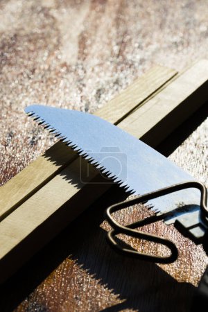 Photo for Hand saw with wooden plank, top view - Royalty Free Image
