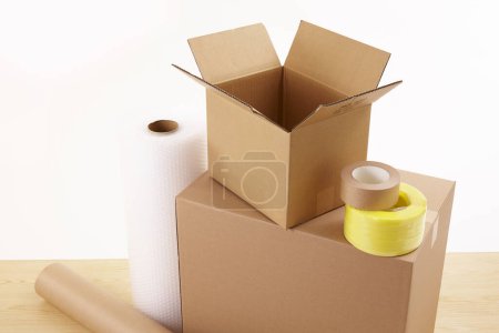 Foto de Cajas de cartón con rollos de papel y cintas adhesivas en la mesa - Imagen libre de derechos