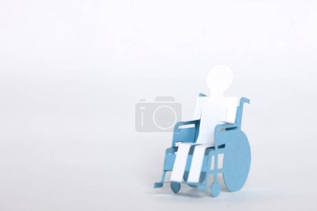 Foto de Hombre de papel blanco en silla de ruedas de papel sobre fondo - Imagen libre de derechos