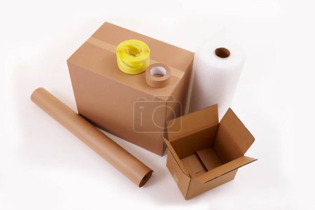 Foto de Cajas de cartón con rollos de papel y cintas adhesivas sobre fondo blanco - Imagen libre de derechos