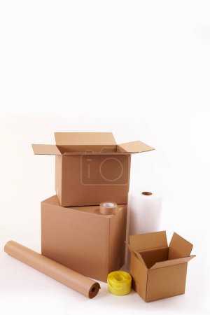 Photo for Cardboard boxes with paper rolls and adhesive tapes on white background - Royalty Free Image