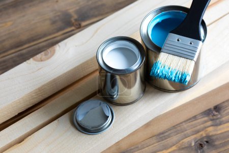 Foto de Conjunto de latas de pintura y pinceles en la superficie de madera - Imagen libre de derechos