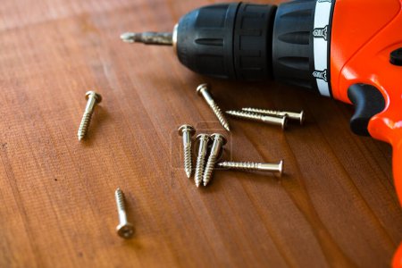 Photo for Screwdriver and screws on a wooden background - Royalty Free Image
