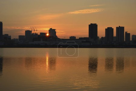 beautiful sunset over the city skyline and reflection in water   