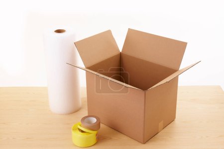 Téléchargez les photos : Boîtes en carton avec rouleaux de papier et rubans adhésifs sur fond blanc - en image libre de droit