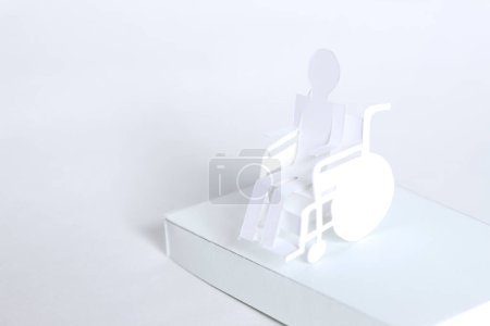 Téléchargez les photos : Papier homme en fauteuil roulant de papier sur fond - en image libre de droit