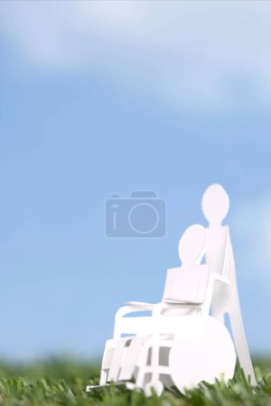 Téléchargez les photos : Papier découpé personnage humain portant une personne en fauteuil roulant, les soins de la famille et de soutien concept fond - en image libre de droit