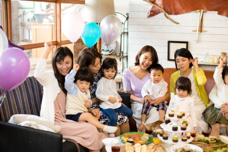 Foto de Mujeres japonesas con niños sentados a la mesa con comida. Concepto de celebración - Imagen libre de derechos