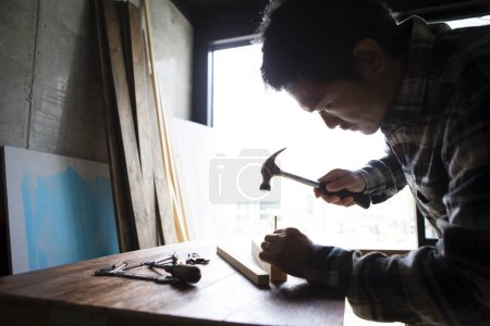 Téléchargez les photos : Vue rapprochée d'un menuisier travaillant sur table à un atelier industriel - en image libre de droit