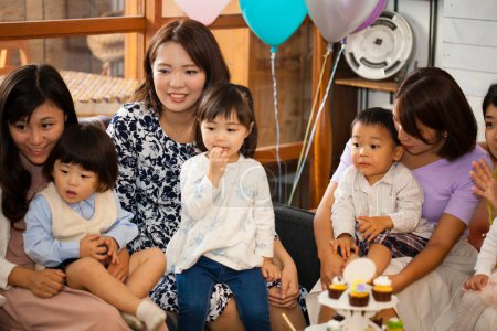 Japanische Frauen mit Kindern sitzen mit Essen am Tisch. Festkonzept