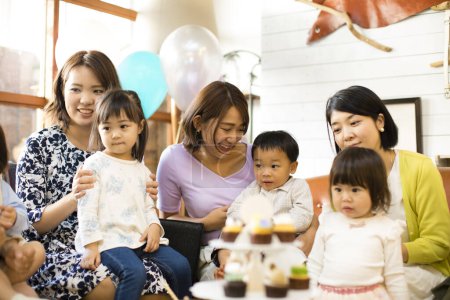 Photo for Japanese women with children sitting at table with food. Celebration concept - Royalty Free Image