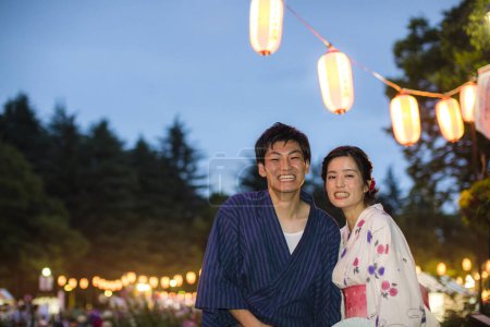 Téléchargez les photos : Jeune couple japonais portant kimono traditionnel dans le parc du soir - en image libre de droit