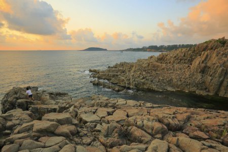 Foto de Hermosa puesta de sol sobre el mar y la costa rocosa - Imagen libre de derechos