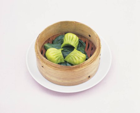 Photo for Chinese steamed dumplings with leaves on white background - Royalty Free Image