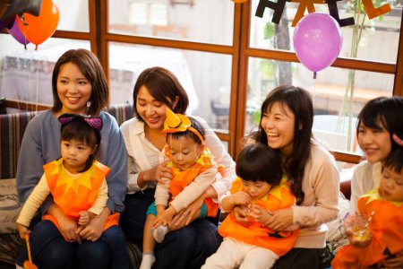 Foto de Mujeres japonesas felices con niños en trajes de calabaza. Halloween - Imagen libre de derechos