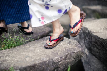 Téléchargez les photos : Section basse de jeune couple japonais portant kimono traditionnel dans le parc d'été - en image libre de droit