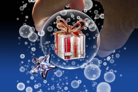 Photo for Male hand holding a glass ball with christmas gift inside - Royalty Free Image