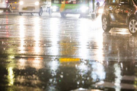 Foto de Coches que conducen por la calle de la ciudad durante la lluvia por la noche - Imagen libre de derechos