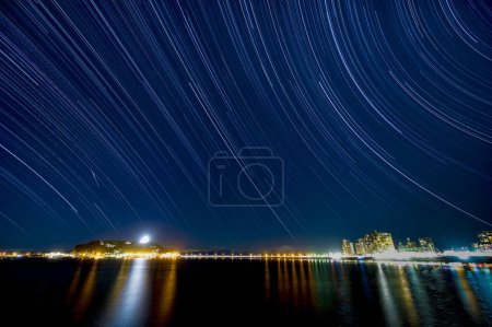 Foto de Hermosa vista de los senderos de estrellas y el mar por la noche - Imagen libre de derechos