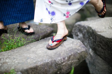 Foto de Sección baja de la joven pareja japonesa que usa kimono tradicional en el parque de verano - Imagen libre de derechos