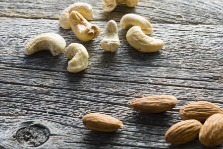 Photo for Cashew and almond nuts on wooden background - Royalty Free Image