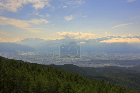 Téléchargez les photos : Panorama de la ville dans la vallée montagneuse et nuages dans le ciel bleu - en image libre de droit