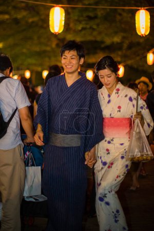 Photo for Young Japanese couple wearing traditional kimono in evening park - Royalty Free Image