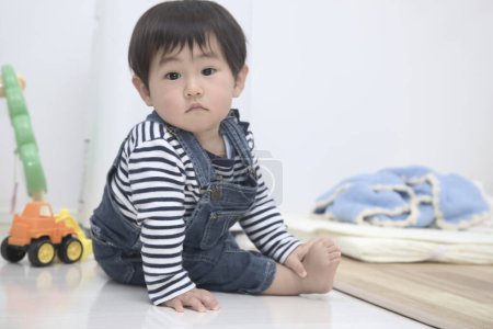 Photo for Cute Asian baby boy sitting on the floor and playing with toys - Royalty Free Image