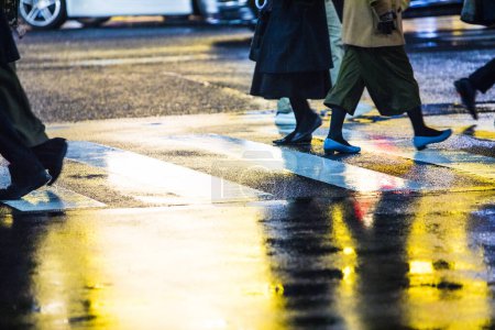 Photo for People walking down the street during rainy evening - Royalty Free Image