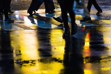 Foto de Gente caminando por la calle durante la noche lluviosa - Imagen libre de derechos