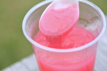 Téléchargez les photos : Gros plan de cocktail rose avec cuillère dans une tasse en plastique - en image libre de droit