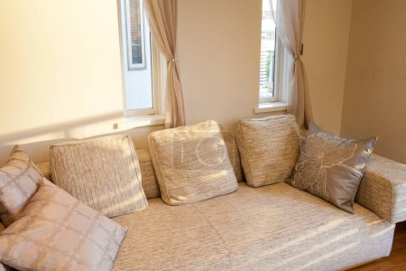 Foto de Un sofá con almohadas y una ventana en el fondo - Imagen libre de derechos