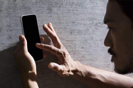 Foto de Hombre asiático sosteniendo teléfono inteligente con pantalla en blanco. Concepto de diseño de publicidad y promoción - Imagen libre de derechos