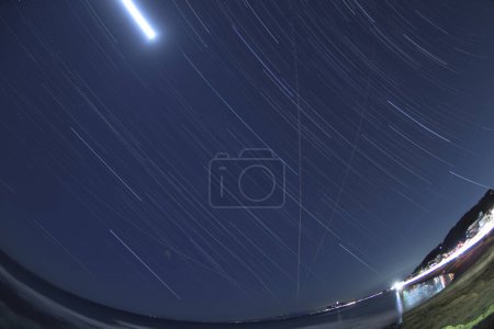 Téléchargez les photos : Belle vue sur les sentiers étoilés et la mer la nuit - en image libre de droit