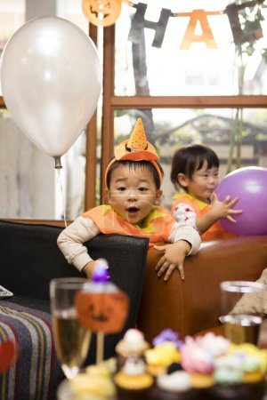 Foto de Lindo asiático niños tener divertido en halloween fiesta. - Imagen libre de derechos