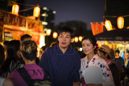 Téléchargez les photos : Jeune couple japonais portant kimono traditionnel dans le parc du soir - en image libre de droit