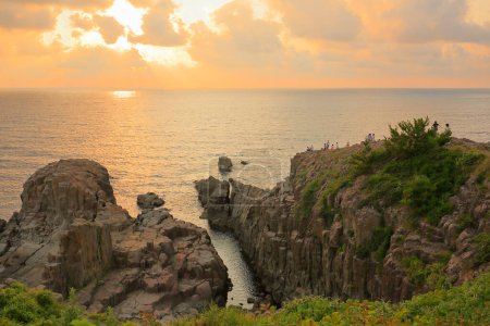 Téléchargez les photos : Beau coucher de soleil sur la mer et le rivage rocheux - en image libre de droit