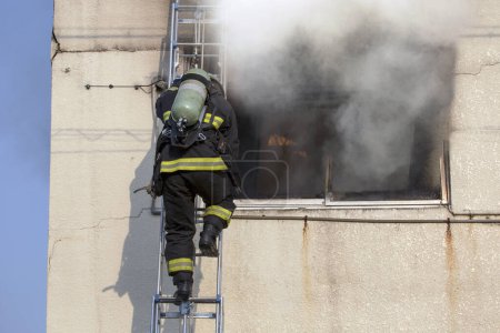 Téléchargez les photos : Pompier éteignant l'incendie dans le bâtiment industriel - en image libre de droit