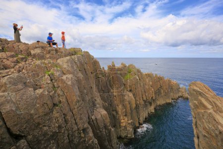 Téléchargez les photos : Personnes debout sur la côte rocheuse et regardant belle vue sur la mer - en image libre de droit