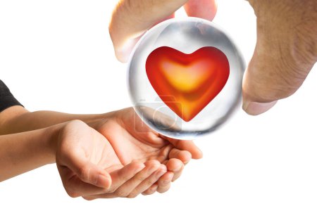 Photo for Male hand giving to woman's hands glass ball with red heart - Royalty Free Image