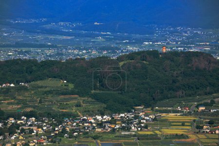 Téléchargez les photos : Panorama de la ville dans la vallée montagneuse et nuages dans le ciel bleu - en image libre de droit