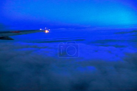 Foto de Hermosa vista nocturna de un ala de avión volando por encima de las nubes - Imagen libre de derechos