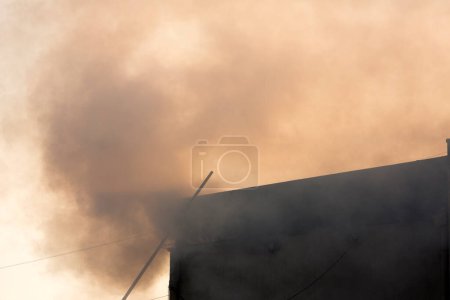 Téléchargez les photos : Flammes de feu et fumée épaisse de la maison - en image libre de droit