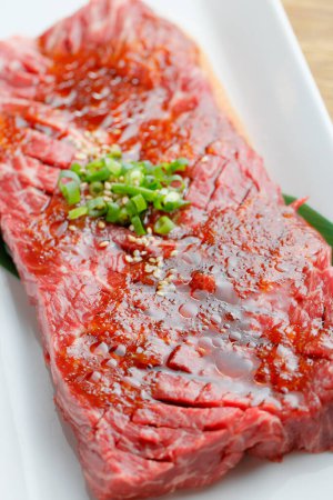 Photo for Fresh raw beef with spices and onion on white plate - Royalty Free Image