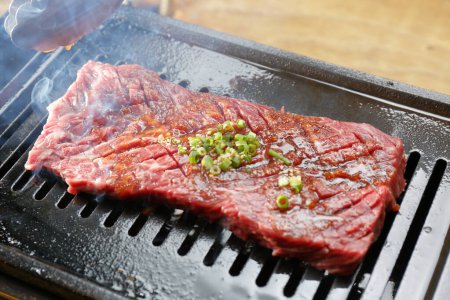 Téléchargez les photos : Steak de boeuf frais et délicieux sur le gril - en image libre de droit