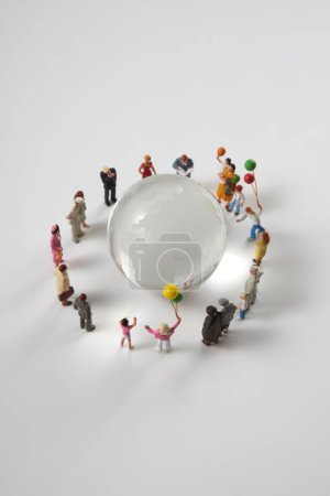 Téléchargez les photos : Figurines miniatures autour du verre globe terrestre sur fond blanc - en image libre de droit