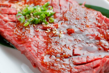 Photo for Fresh raw beef with spices and onion on white plate - Royalty Free Image