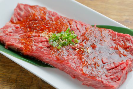 Téléchargez les photos : Steak de boeuf frais avec oignon vert dans l'assiette - en image libre de droit